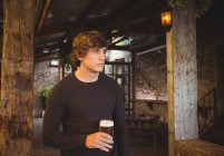 Человек держит стакан пива в баре — стоковое фото