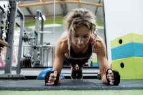 Woman performing push-up exercise in gym — Stock Photo