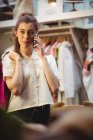 Femme parlant sur téléphone portable tout en faisant du shopping dans le magasin de boutique — Photo de stock