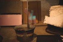 Nahaufnahme eines Blasrohres in einem Eimer mit Wasser in der Glasbläserei — Stockfoto