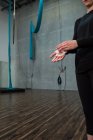 Gymnast rubbing chalk powder on hands in fitness studio — Stock Photo