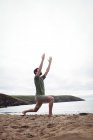 Uomo che esegue esercizio di stretching sulla spiaggia — Foto stock