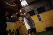 Low angle view of two thai boxers practicing boxing in gym — Stock Photo