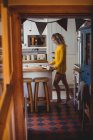Красива жінка, використовуючи цифровий планшетний маючи Кава у кухні в домашніх умовах — стокове фото