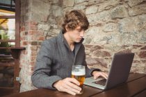 Homem usando laptop no bar — Fotografia de Stock