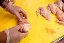 Руки мясника готовят курицу и стейк в мясной лавке — стоковое фото