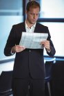 Бизнесмен читает финансовый отчет в офисе — стоковое фото