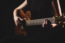 Студентка средней школы играет на гитаре в студии — стоковое фото