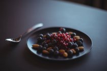 Гранат, чорниця і мигдаль в тарілці в ресторані — стокове фото