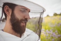 Primer plano del apicultor que trabaja en el campo - foto de stock