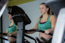 Schwangere trainiert im Fitnessstudio an Crossgerät — Stockfoto