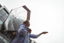 Vista basso angolo di Bella donna godendo la pioggia durante la stagione delle piogge — Foto stock