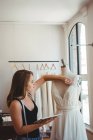 Female fashion designer adjusting the dress on a mannequin in the studio — Stock Photo