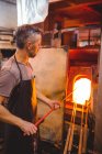 Митець опалення скла в печі при glassblowing заводу — стокове фото