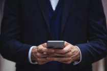 Mid section of businessman using mobile phone — Stock Photo