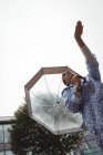 Baixo ângulo de visão da mulher bonita desfrutando de chuva durante a estação chuvosa — Fotografia de Stock