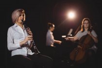 Drei Studentinnen spielen Kontrabass, Klarinette und Klavier in einem Studio — Stockfoto