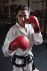 Retrato de boxeador feminino em luvas de boxe vermelho olhando para a câmera no estúdio de fitness — Fotografia de Stock
