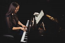 Studente donna che suona il pianoforte in uno studio — Foto stock
