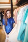 Mujer seleccionando una ropa de perchas en la tienda boutique - foto de stock