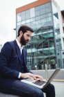 Aufmerksamer Geschäftsmann benutzt Laptop außerhalb des Büros — Stockfoto