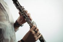 Sección media de la mujer tocando un clarinete en la escuela de música - foto de stock