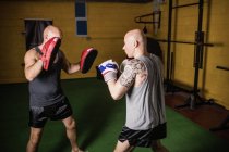 Vista lateral de dos boxeadores tailandeses practicando en el gimnasio - foto de stock