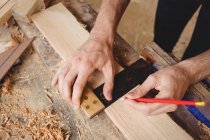 Руки человека, работающего над деревянной доской на лодочной верфи — стоковое фото