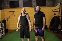 Retrato de dois pugilistas tailandeses confiantes em pé no estúdio de fitness — Fotografia de Stock