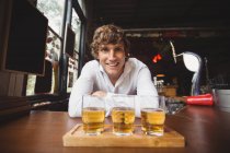 Портрет бармена с подносом стаканов виски у барной стойки в баре — стоковое фото