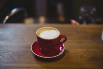 Tasse Cappuccino auf dem Tisch im Fahrradladen — Stockfoto