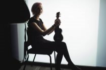 Retrato de mujer sentada con una guitarra en la escuela de música - foto de stock