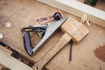 Handhobel und Hammer auf Holzplanke in Bootswerft — Stockfoto