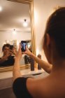 Женщина делает селфи с мобильного телефона в салоне красоты — стоковое фото