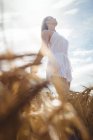 Low angle view of Woman in white dress looking up — Stock Photo
