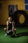 Schöner tätowierter Sportler beim Gewichtheben im Fitnessstudio — Stockfoto