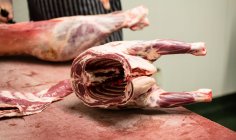 Carcasse di maiale tenute in tavola in macelleria — Foto stock