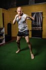 Schöner thailändischer Boxer beim Boxen im Fitnessstudio — Stockfoto