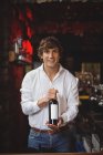 Портрет бармена, держащего бутылку вина в баре — стоковое фото