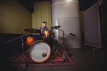 Étudiant homme jouant de la batterie dans un studio — Photo de stock