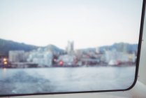 Blurred view of harbor city from window glass pane — Stock Photo