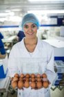 Porträt weiblicher Mitarbeiter mit Eierschale in Fabrik — Stockfoto