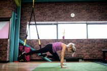 Frau trainiert mit Widerstandsband im Fitnessstudio — Stockfoto