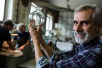 Portrait de souffleur de verre regardant la verrerie dans l'usine de soufflage de verre — Photo de stock