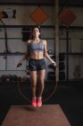 Femme faisant de l'exercice avec corde à sauter dans un studio de fitness — Photo de stock
