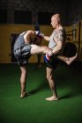 Deux boxeurs thaïlandais pratiquant la boxe dans un studio de fitness — Photo de stock