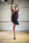Bajo ángulo vista de bailarina en tutú oscuro bailando en estudio - foto de stock