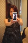 Молодая азиатка делает селфи с мобильного телефона в бутик-магазине — стоковое фото