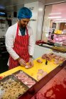 Butcher preparing a chicken and steak roll in butchers shop — Stock Photo