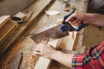 Uomo che taglia una tavola di legno al cantiere navale — Foto stock